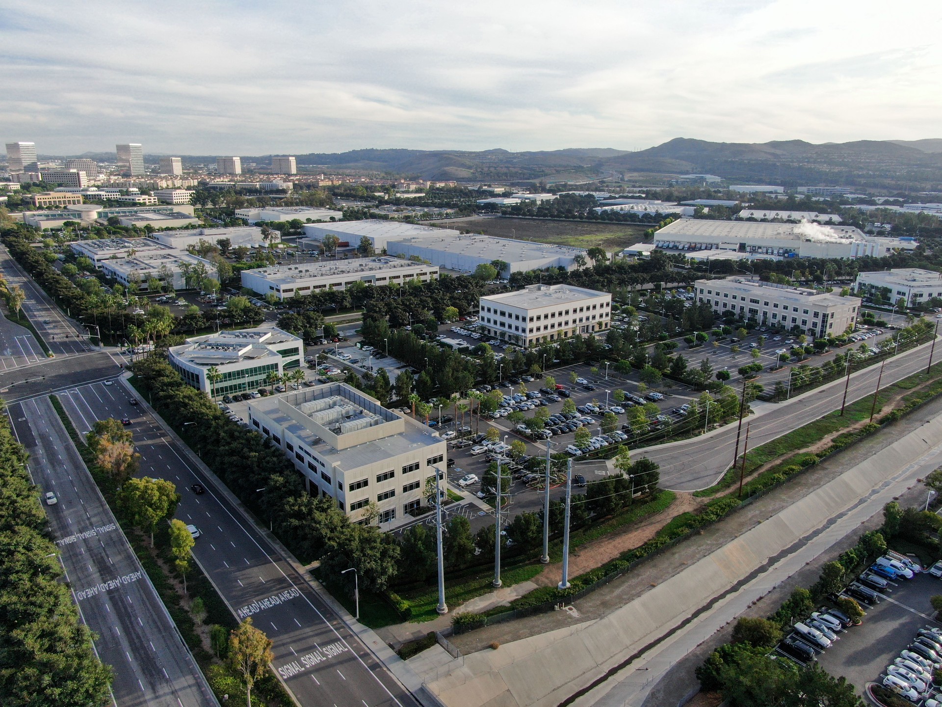 Aerial view of business and finance district with new office building surrounded by parking and road
